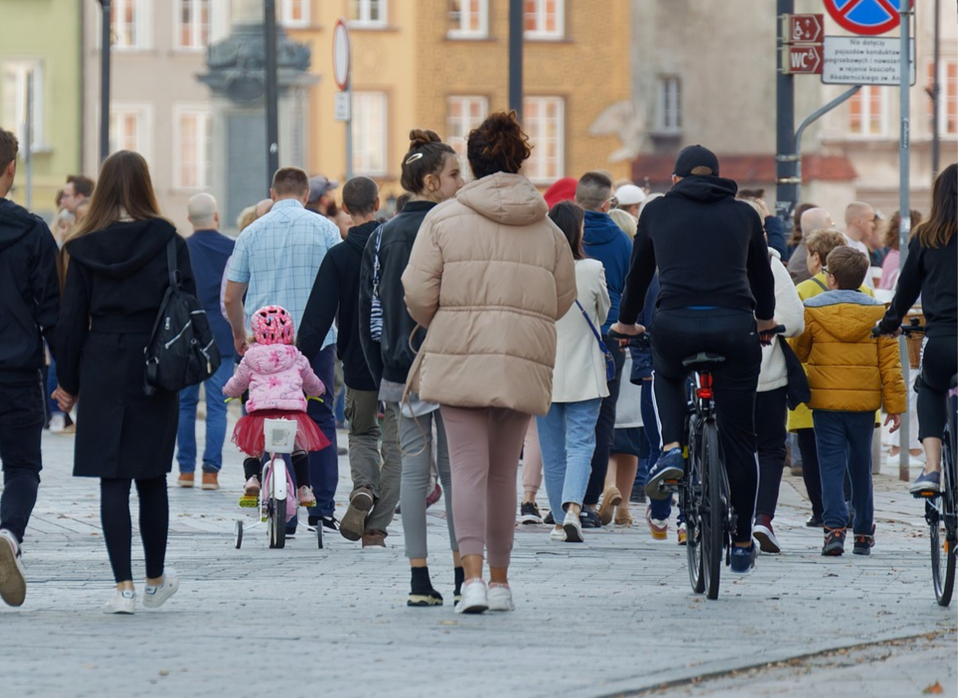 a large crowd of people walking down the street - public liability insurance