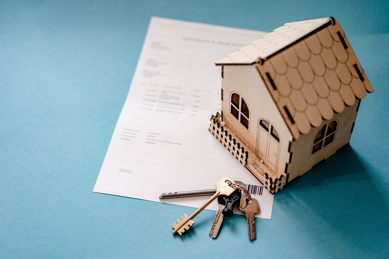 A piece of paper with keys and a wooden house on top - home insurance